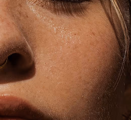 Close-up of lips with a gold septum ring on a person with light brown skin.