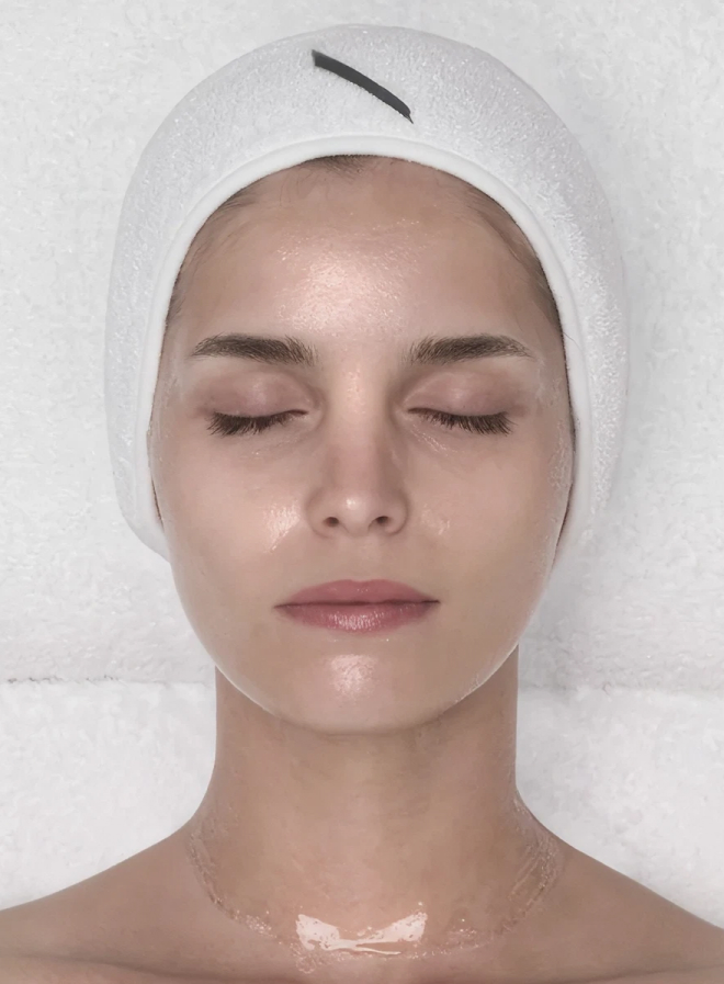 Close-up of a person's face showing closed eyes, nose, lips, and textured skin with small blemishes.
