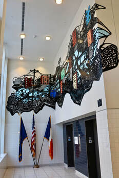 Large colorful cityscape mural installation in school lobby