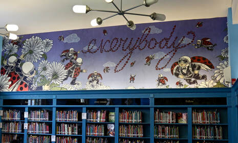 Colorful everybody mural above library bookshelves with ladybug characters