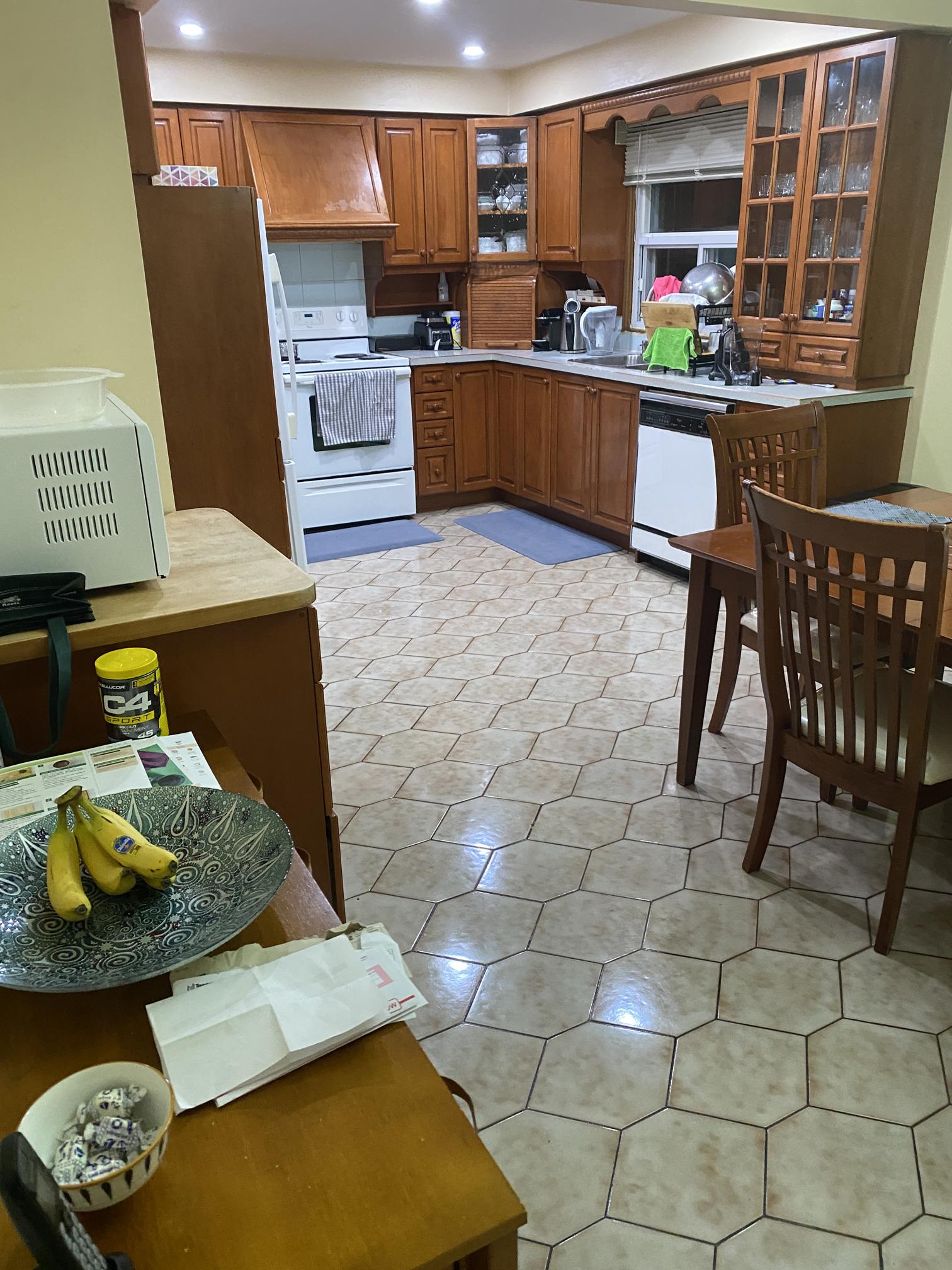 Before photo of the original Vaughan Fiori kitchen showing outdated cabinets, ceramic tile flooring, and existing kitchen finishes before renovation.