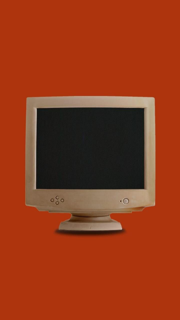 Beige retro CRT computer monitor with a blank black screen on a red background.