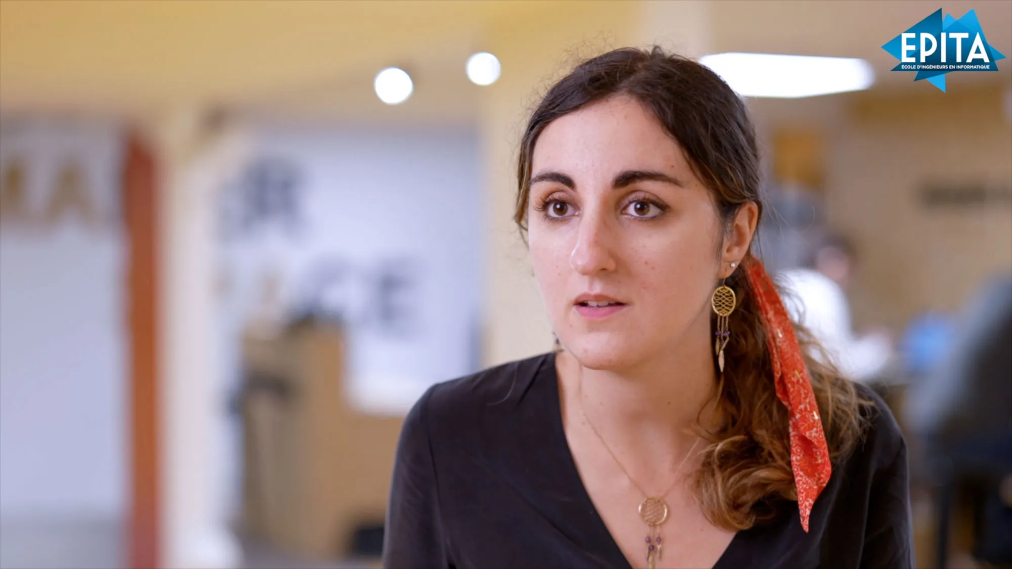 Une chercheuse répond à une question face caméra dans un atelier universitaire