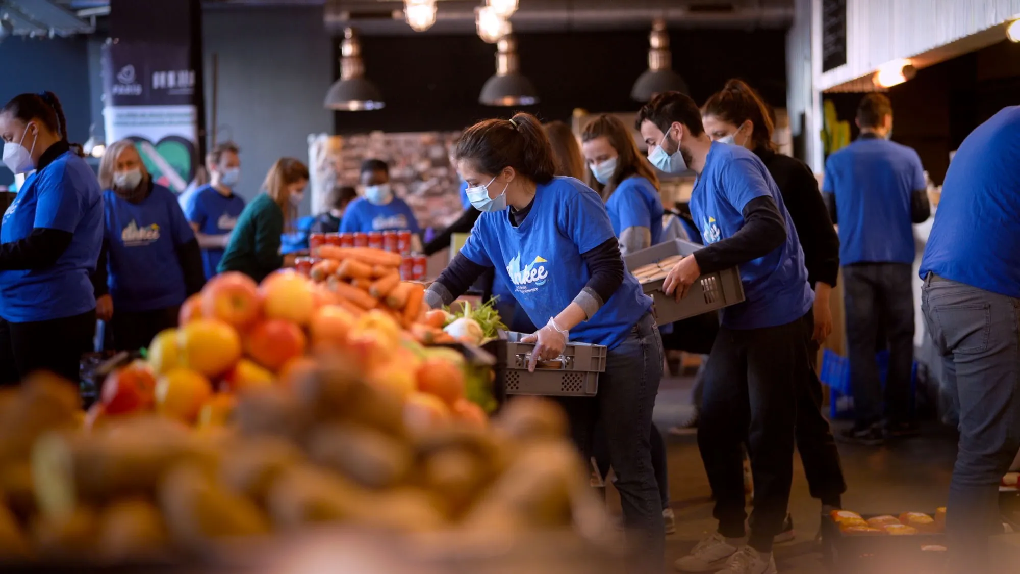 Des bénévoles trient des fruits et légumes dans un entrepôt de banque alimentaire