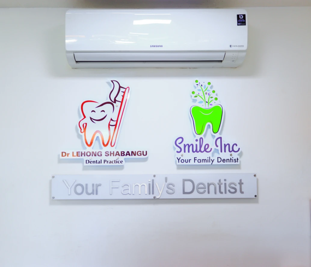 Wall signs for Dr Lehong Shabangu Dental Practice and Smile Inc Your Family Dentist below a Samsung air conditioner in Centurion.
