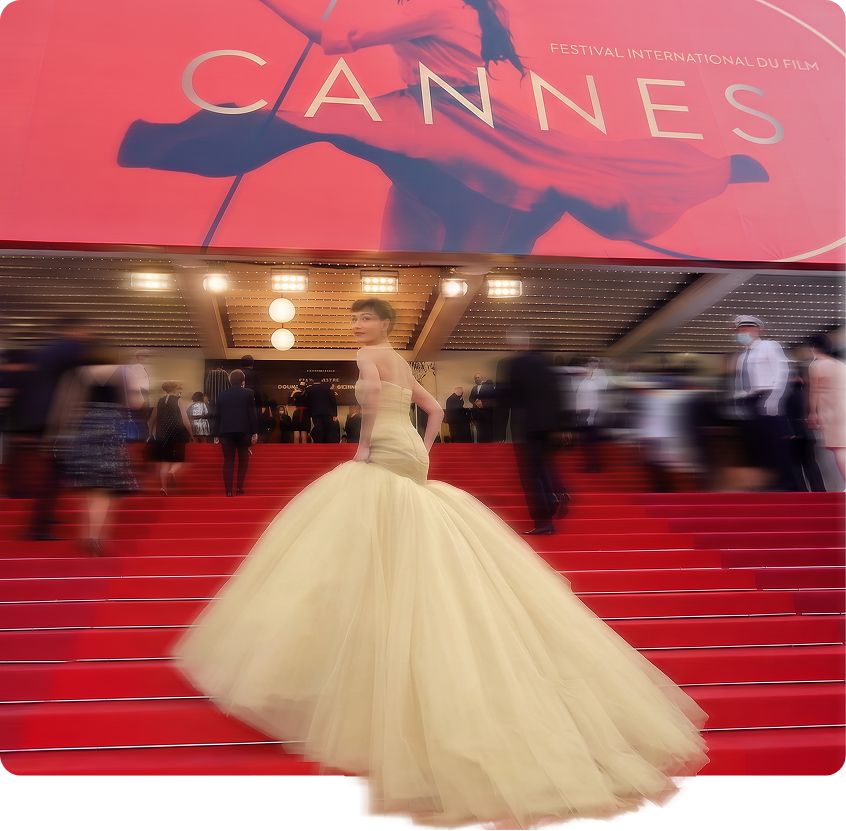 Guest in a cream tulle gown on the Cannes red carpet steps