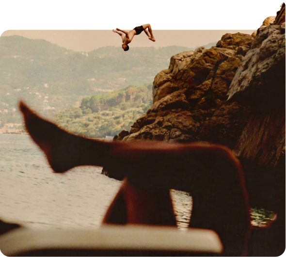 Legs stretched out on a sun lounger above a rocky coastline