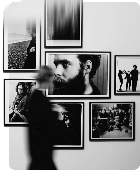 Visitor passing a wall of black and white framed photographs