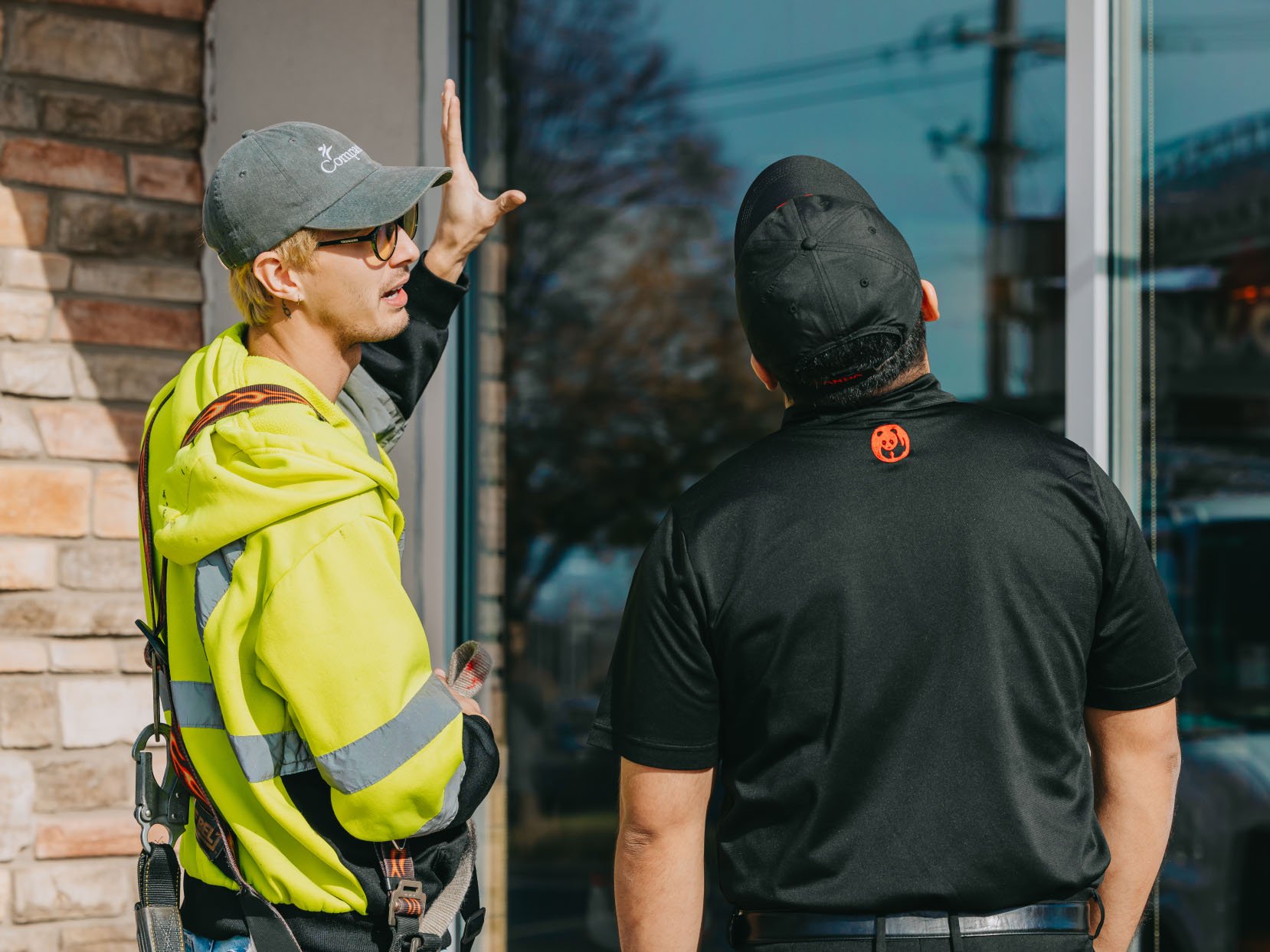 Two Rick Signs technicians on site at a Chicago commercial building during a sign repair consultation