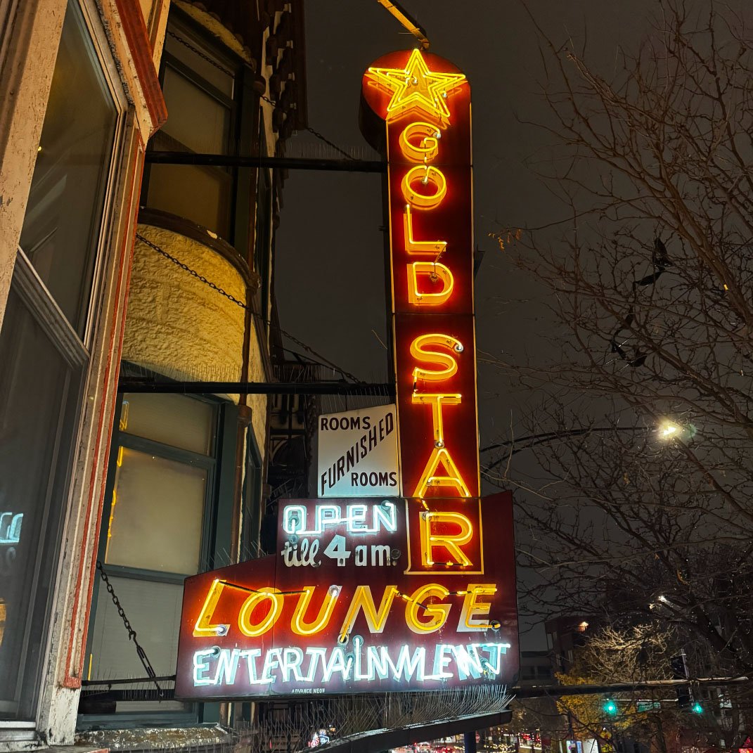 Vintage Gold Star Lounge neon sign glowing at night against the Chicago skyline — Rick Signs neon sign repair and restoration