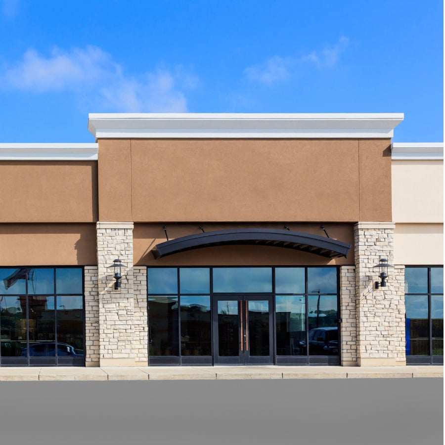 Modern commercial storefront with stone column entry — Rick Signs sign and lighting maintenance contracts for Chicago property managers