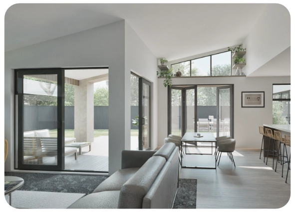 Modern living room with gray sofa, black-framed glass doors, indoor plants, and bar stools at kitchen counter.