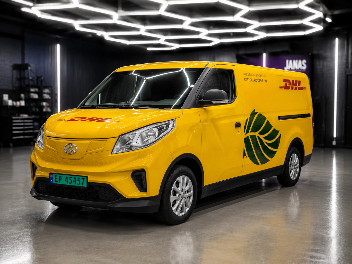 Yellow DHL electric delivery van with green leaf logo parked in a modern garage with hexagonal lights.