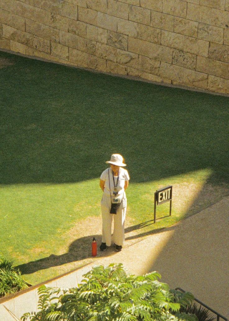 An older Australian pausing on a sunlit garden path