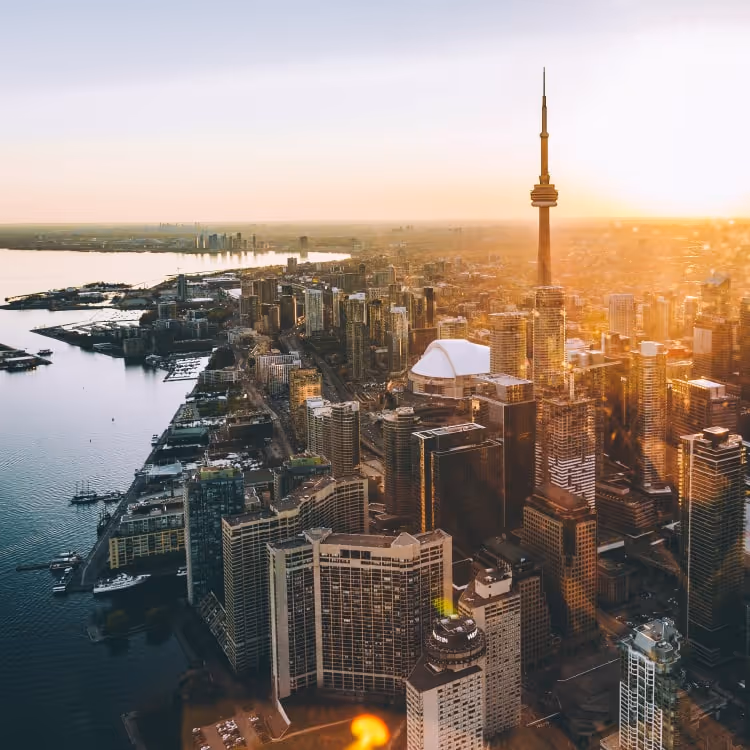 Aerial view of Toronto skyline with CN Tower at sunset over Lake Ontario.