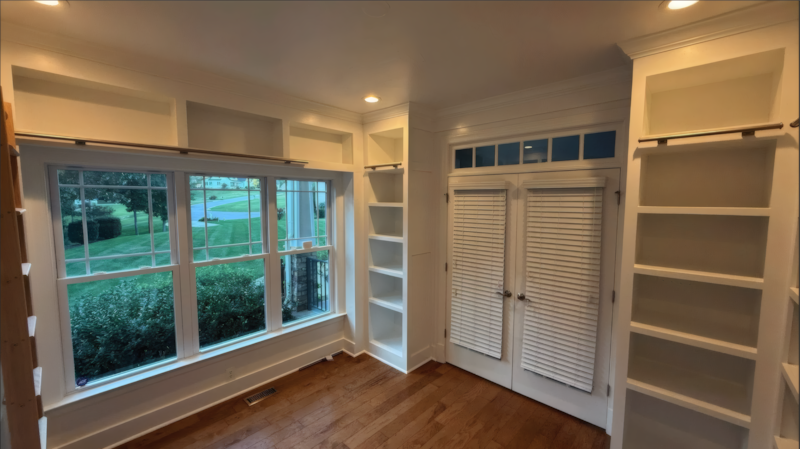 Floor-to-ceiling custom built-in bookshelves with library ladder