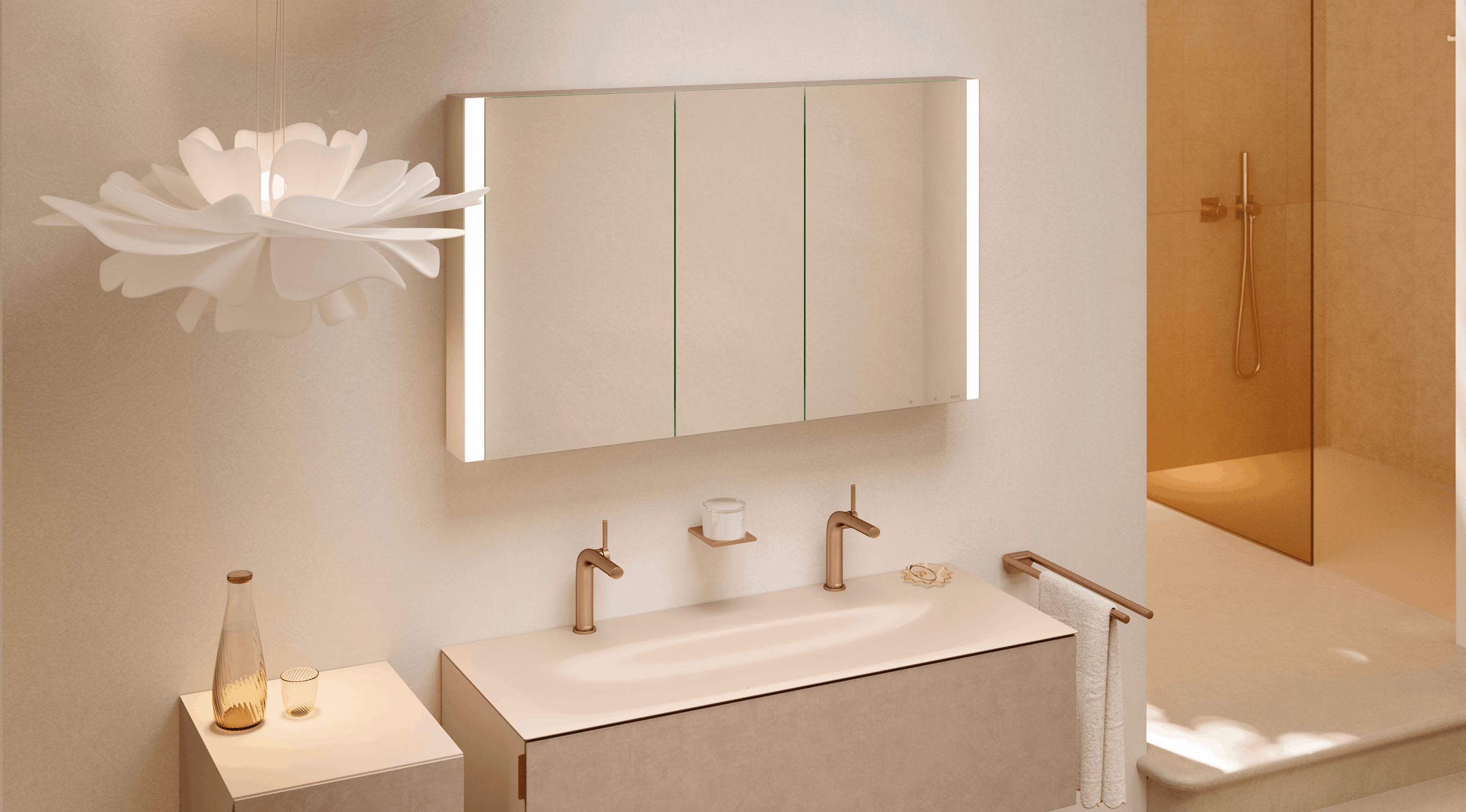Modern bathroom with a double sink vanity featuring minimalist bronze faucets, a wall-mounted mirrored cabinet with vertical lights on sides, a towel rack with white towels, a small cabinet with a glass bottle and a cup, and a shower area with a glass door and bronze showerhead.