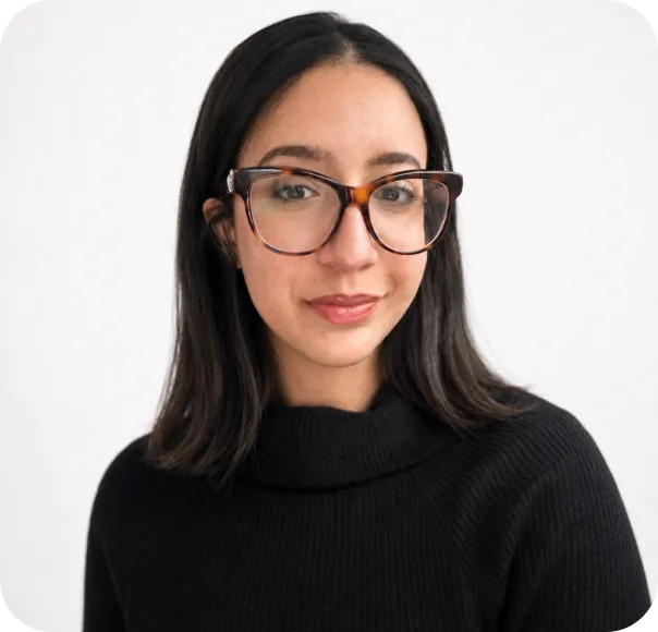 Young woman with straight dark hair and glasses wearing a black turtleneck sweater.