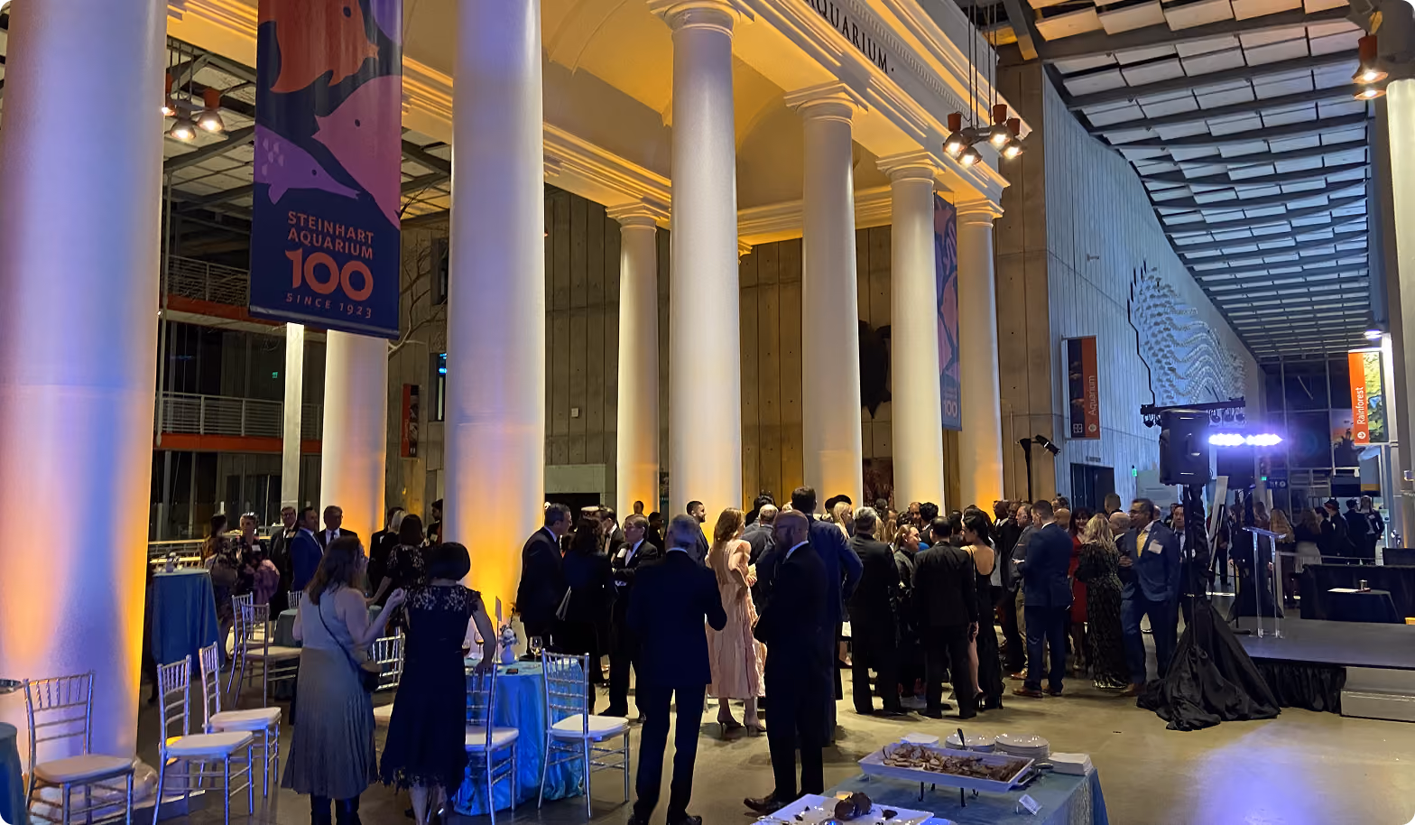 Evening reception in a columned hall with warm amber uplighting