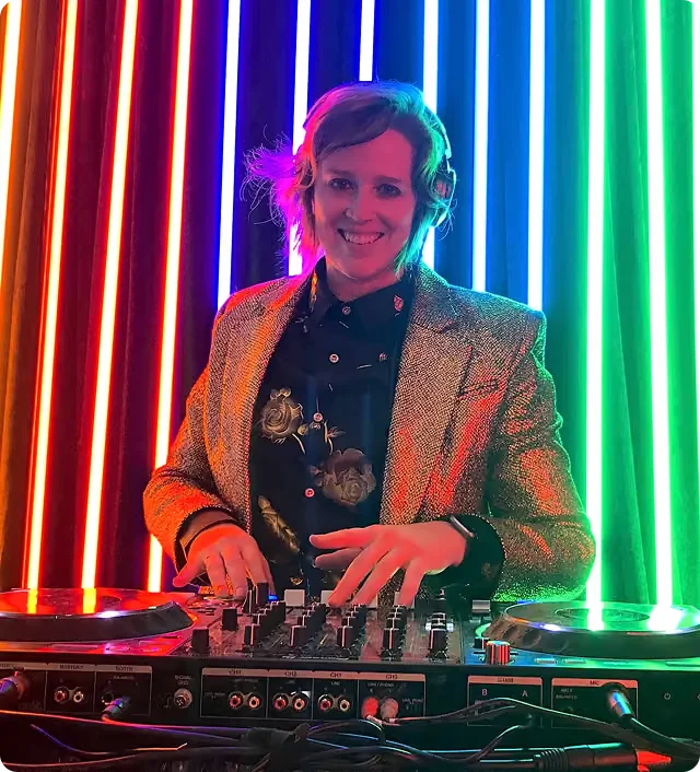 DJ Airsun (Ersson) in a gold jacket at the decks in front of rainbow LED lights