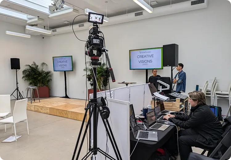 AV tech running a camera and laptop at a corporate presentation
