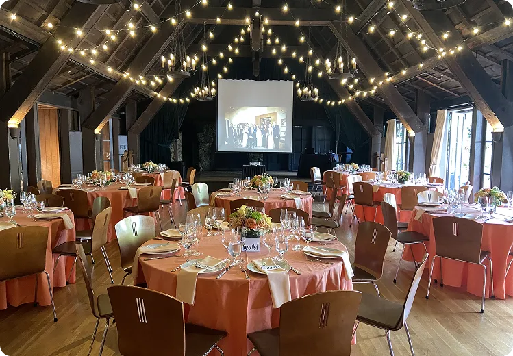 Wedding reception under string lights with a projection screen