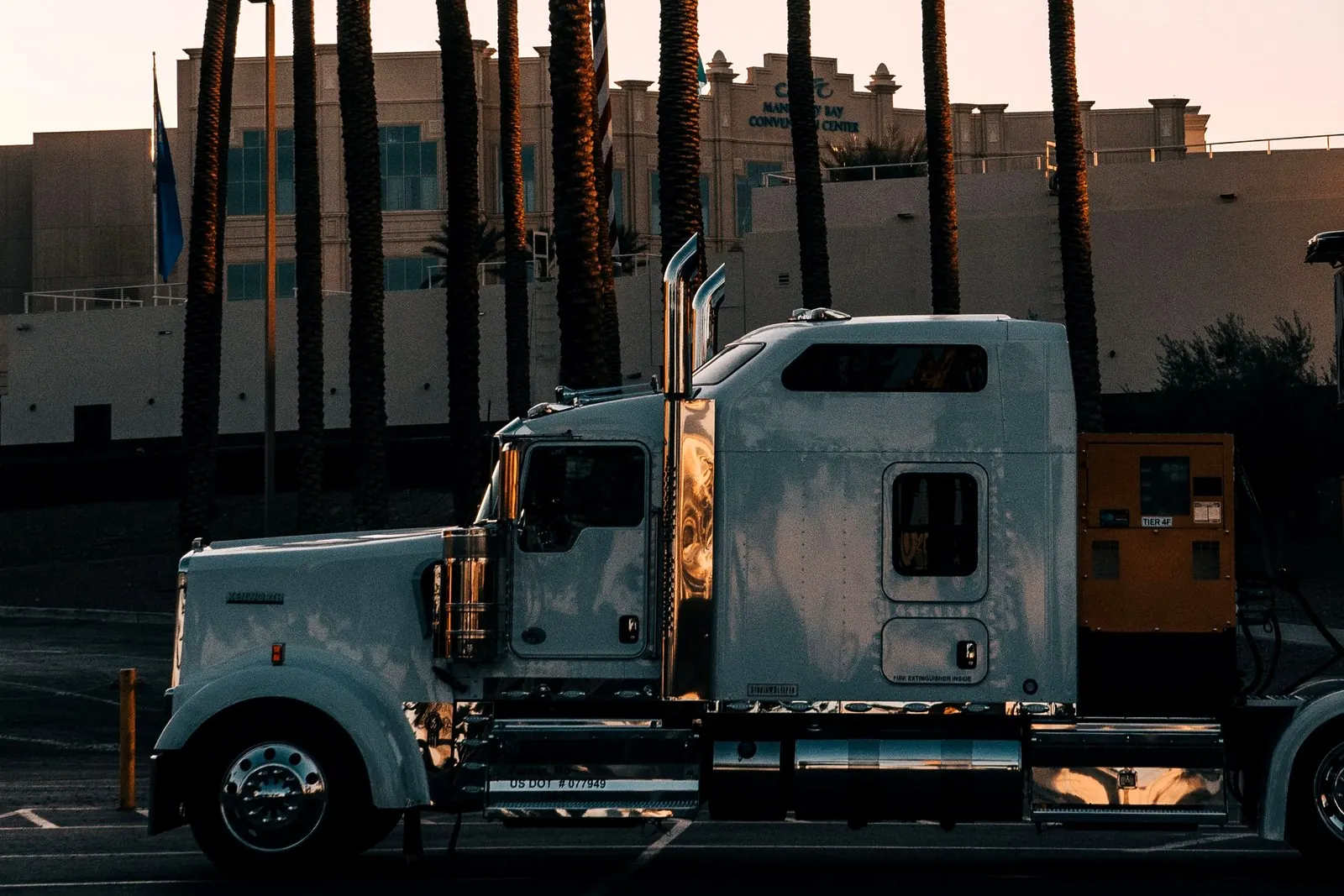Long-haul tractor parked at dusk with palm trees, Southern California freight corridor