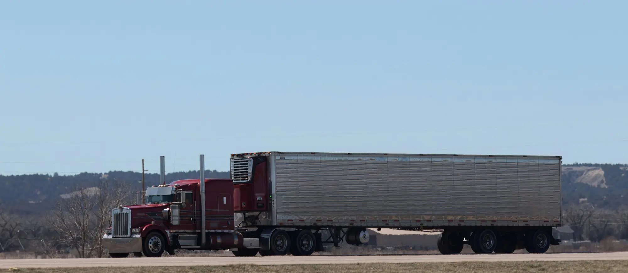 Refrigerated LTL freight moving by reefer trailer on a Western highway lane