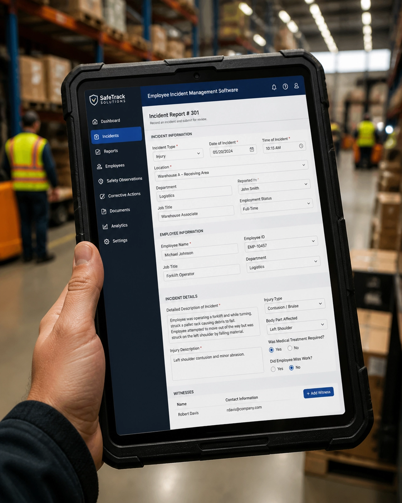 A supervisor using employee incident management software on a tablet in a warehouse.