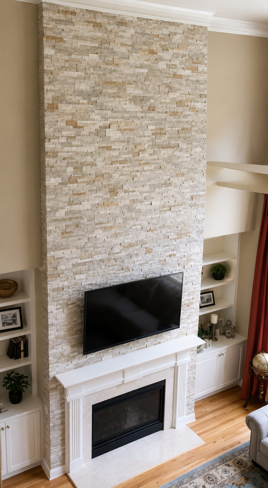 Floor-to-ceiling light stacked stone fireplace wall with a white mantel, mounted television, and surrounding built-in cabinetry in Huntersville, NC