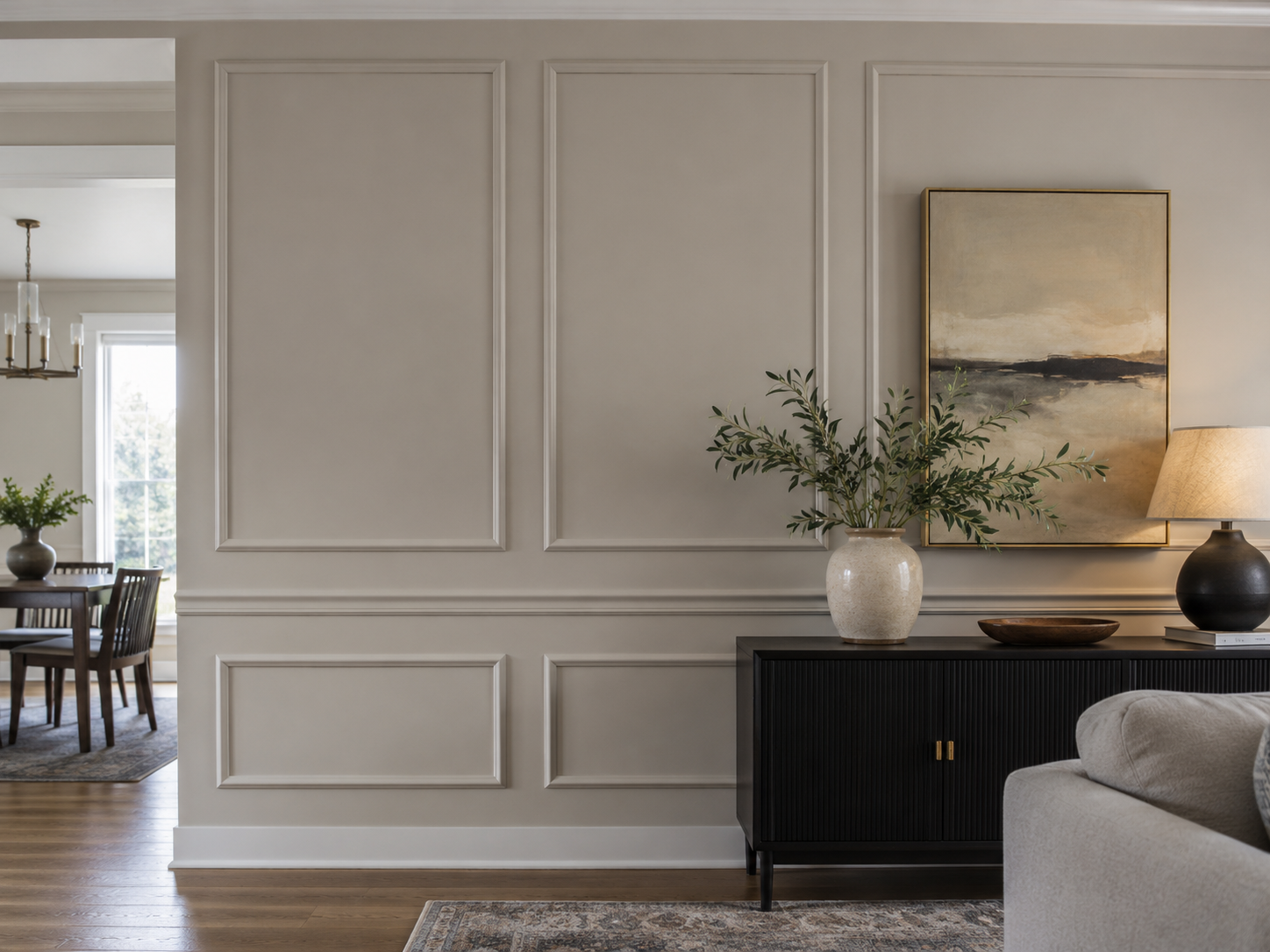 Warm gray living room accent wall with symmetrical painted box molding and decorative trim panels in Concord, NC