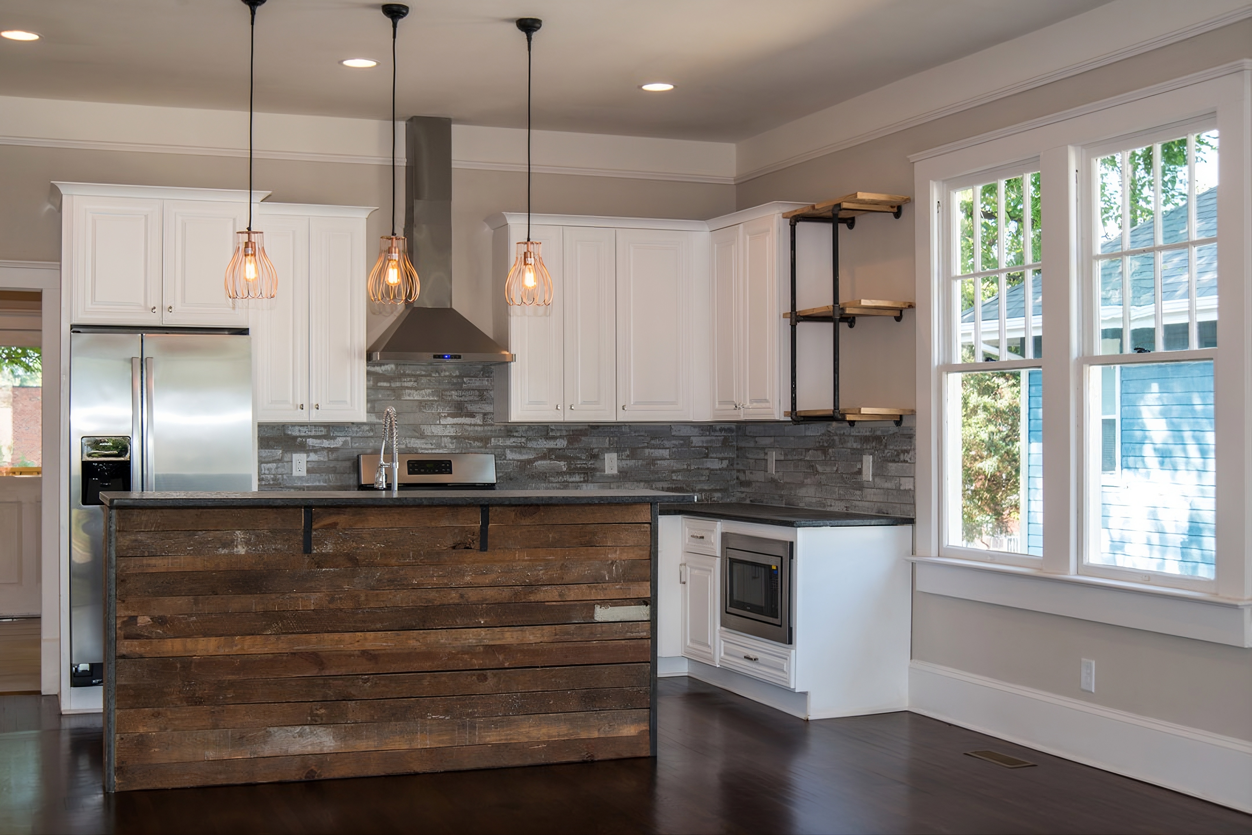 Gray textured tile backsplash installed beneath white kitchen cabinets with stainless steel appliances and a reclaimed wood island in Charlotte, NC in the Wilmore area.