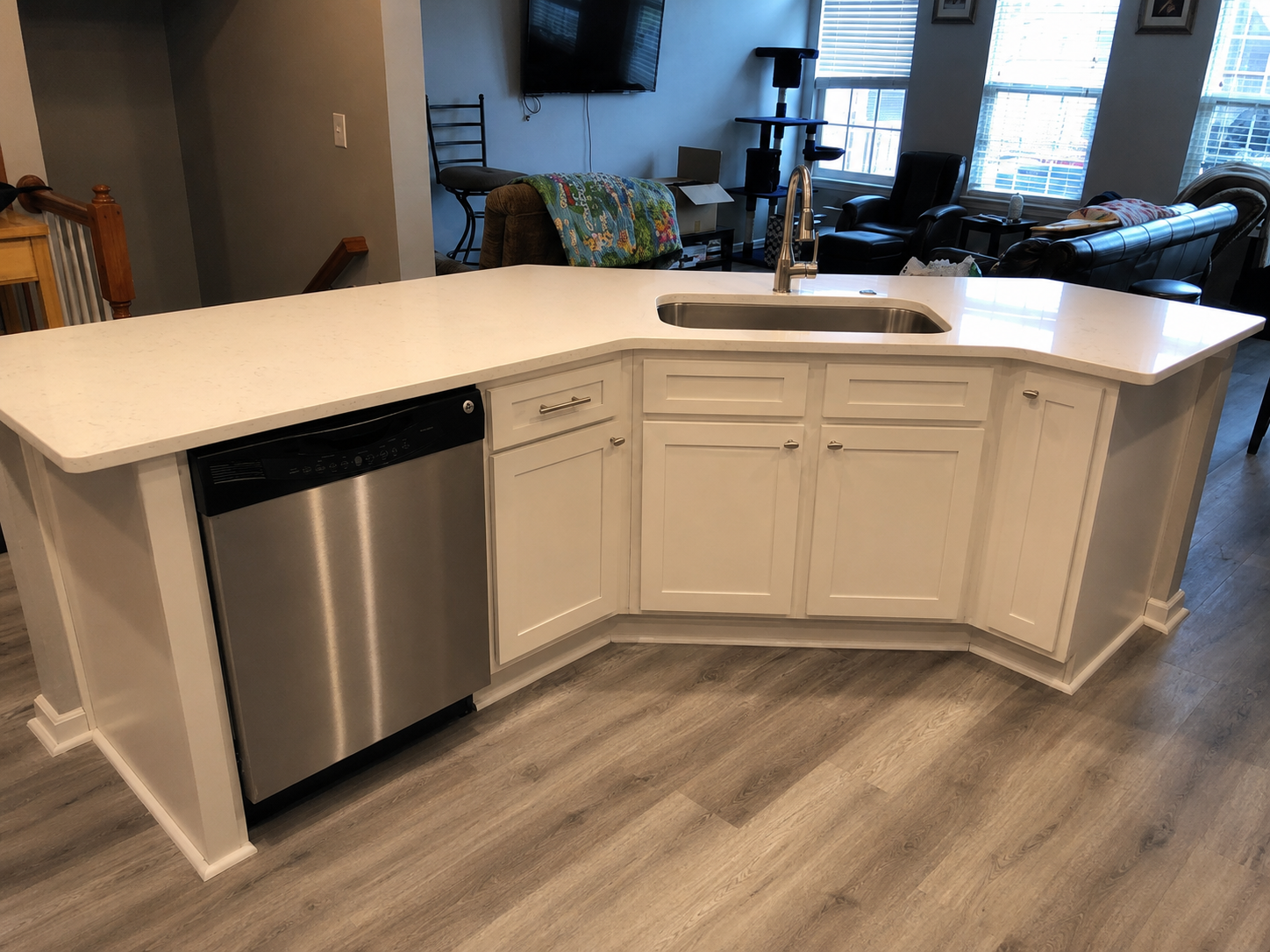 White kitchen peninsula with quartz countertop, undermount sink, stainless dishwasher, shaker cabinetry, and gray wood-look flooring in Harrisburg, NC