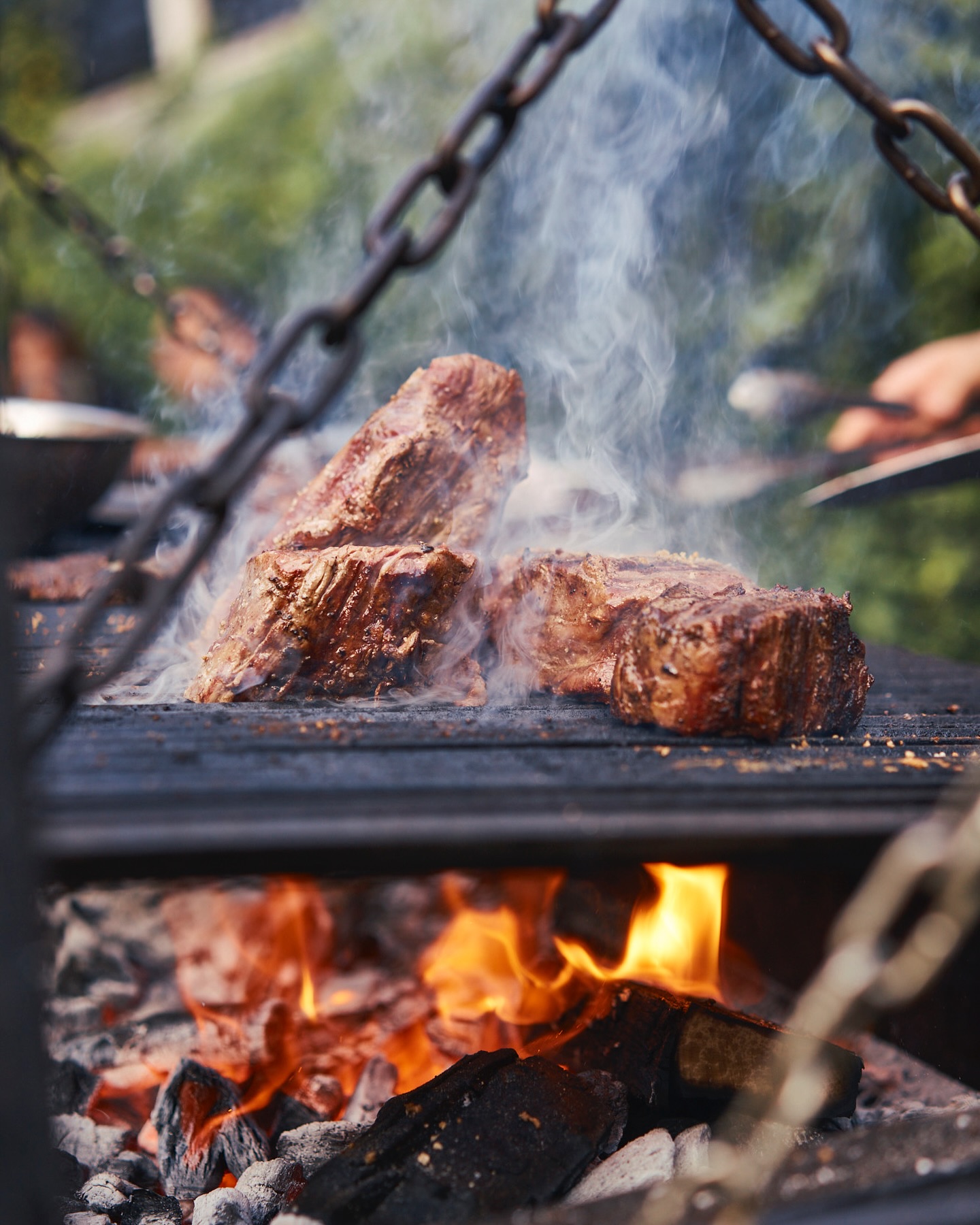 Costilla de res asándose a las brasas en el horno de DANTE Brasa y Fuego