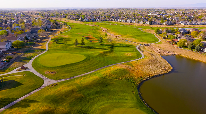 Aerial drone photo of the Ute Creek Golf Course neighborhood in Longmont, Colorado, with an 18-hole course and mountain views.
