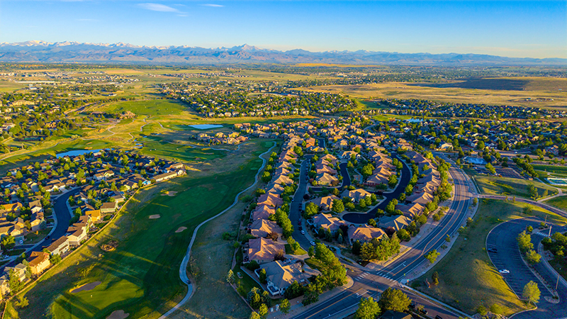 Aerial drone photo of the Vista Ridge neighborhood in Erie, Colorado, with newer homes, parks, and mountain views.