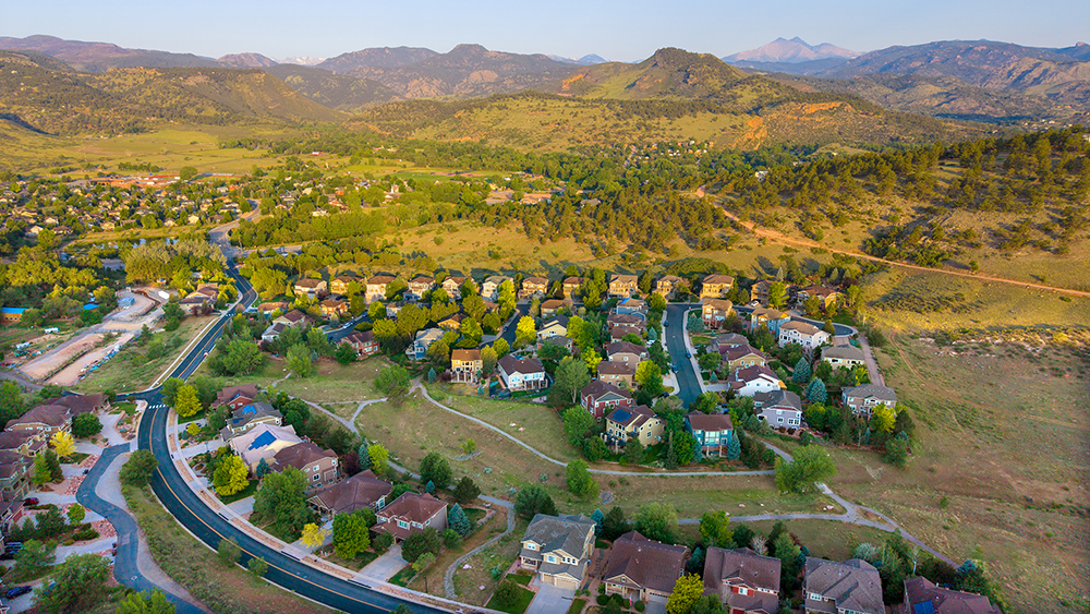 Aerial drone photo of the Stone Canyon neighborhood in Lyons, Colorado, with red rock hogbacks and valley views toward Longs Peak.