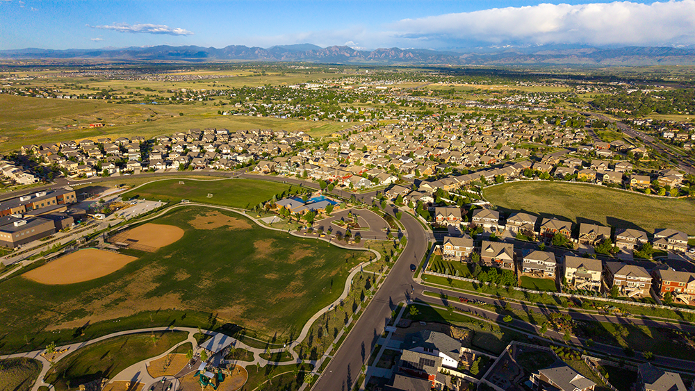 Aerial drone photo of the Erie Highlands neighborhood in Erie, Colorado, with a community clubhouse, parks, and Front Range views.