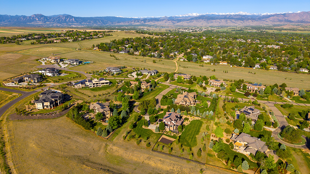 Aerial drone photo of the Niwot Hills neighborhood in Niwot, Colorado, with rolling terrain, large lots, and foothills views.