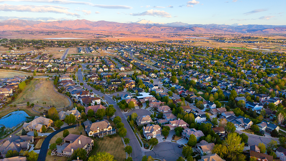 Aerial drone photo of the Somerset Meadows neighborhood in southwest Longmont, Colorado, with newer homes and wide streets.