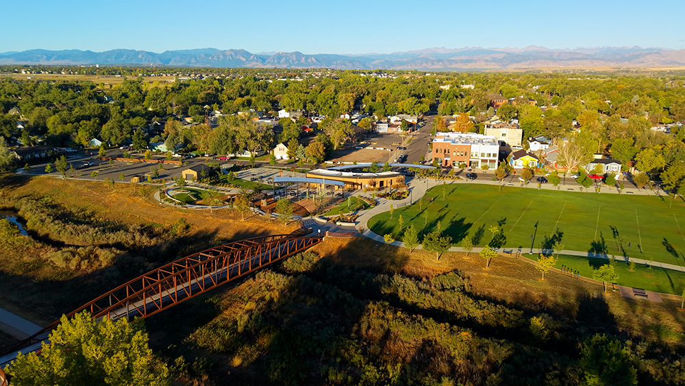 Aerial drone photo of Old Town Erie, Colorado, with historic brick storefronts on Briggs Street, tree-lined streets, and Front Range views.