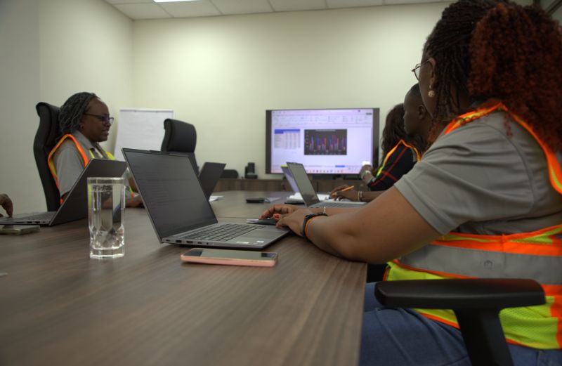 Colleagues working on laptops around a meeting room table