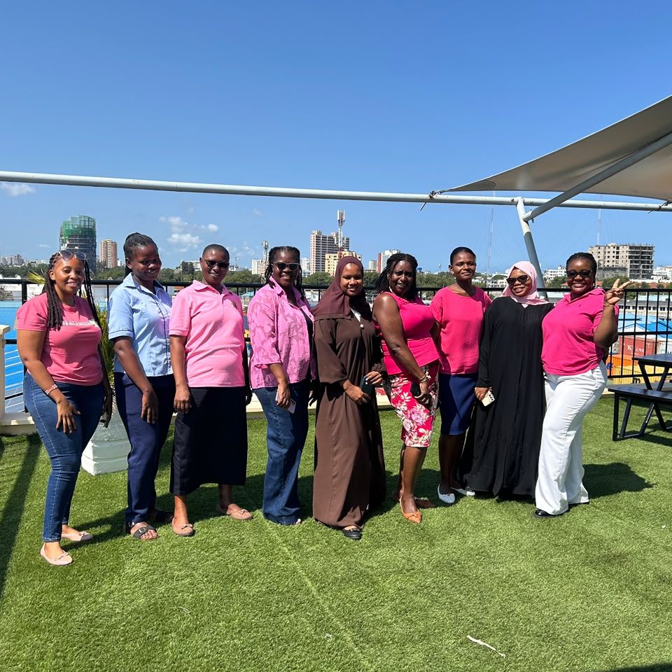 Women from the team dressed in pink on a rooftop terrace