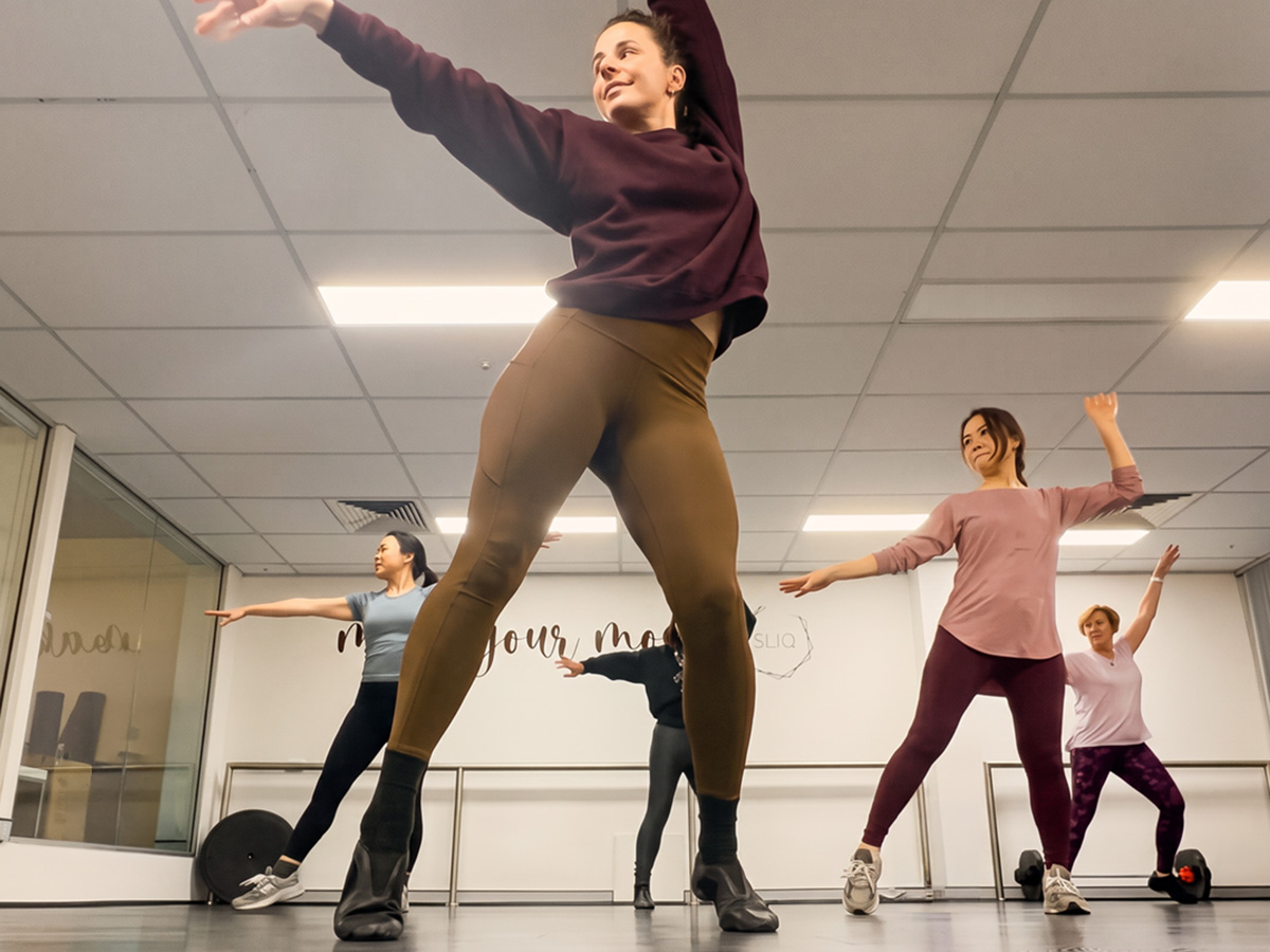 Women taking part in an energetic group dance fitness class at SLIQ