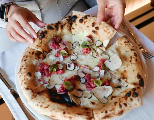 Freshly baked pizza topped with shaved truffles.
