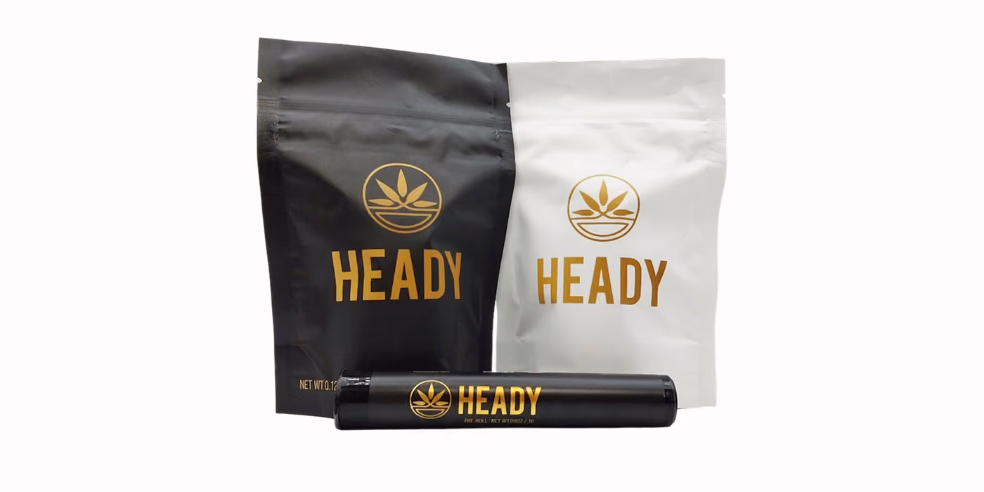 Two Heady brand resealable bags, one black and one white, and a black pre-roll container with gold logo.