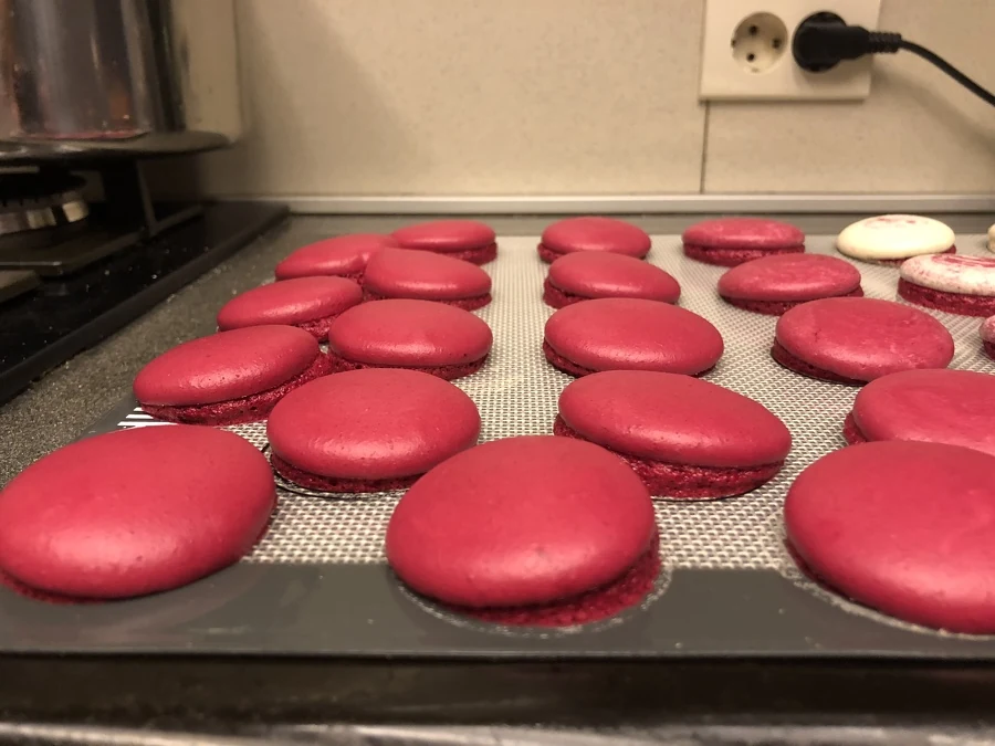 Red macaron shells with uneven rise around their sides