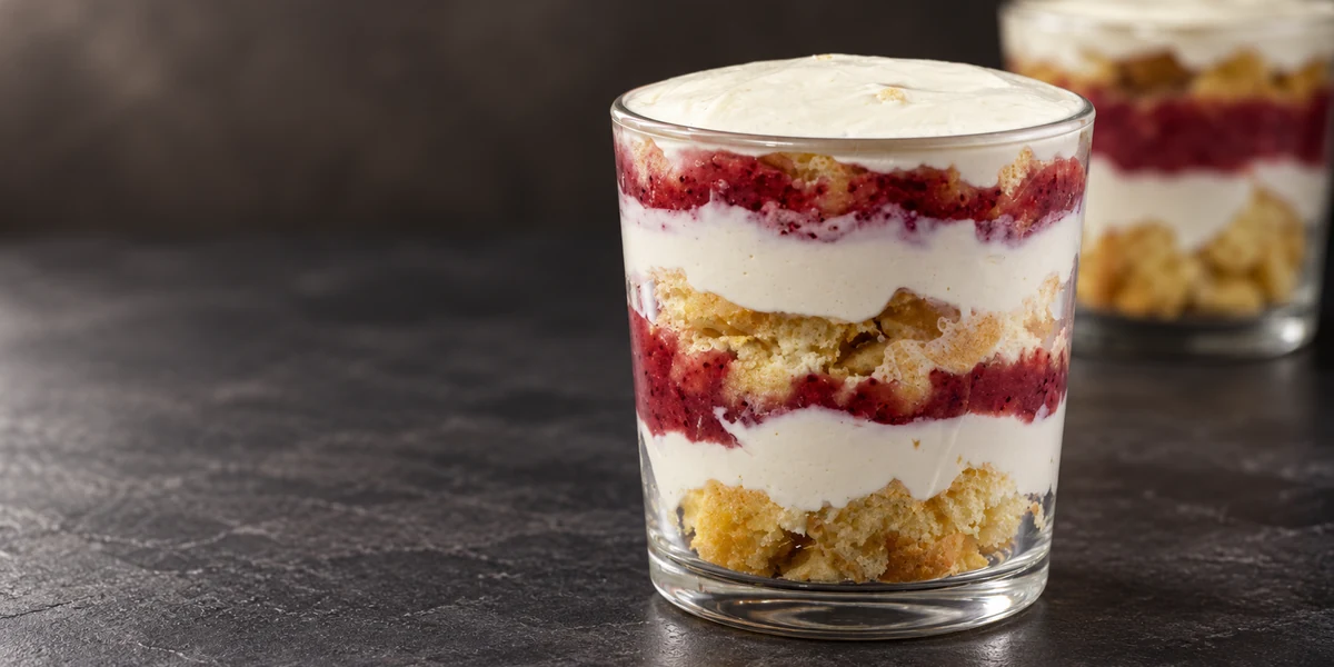 Individual dessert cups layered with sponge, cream and berry filling