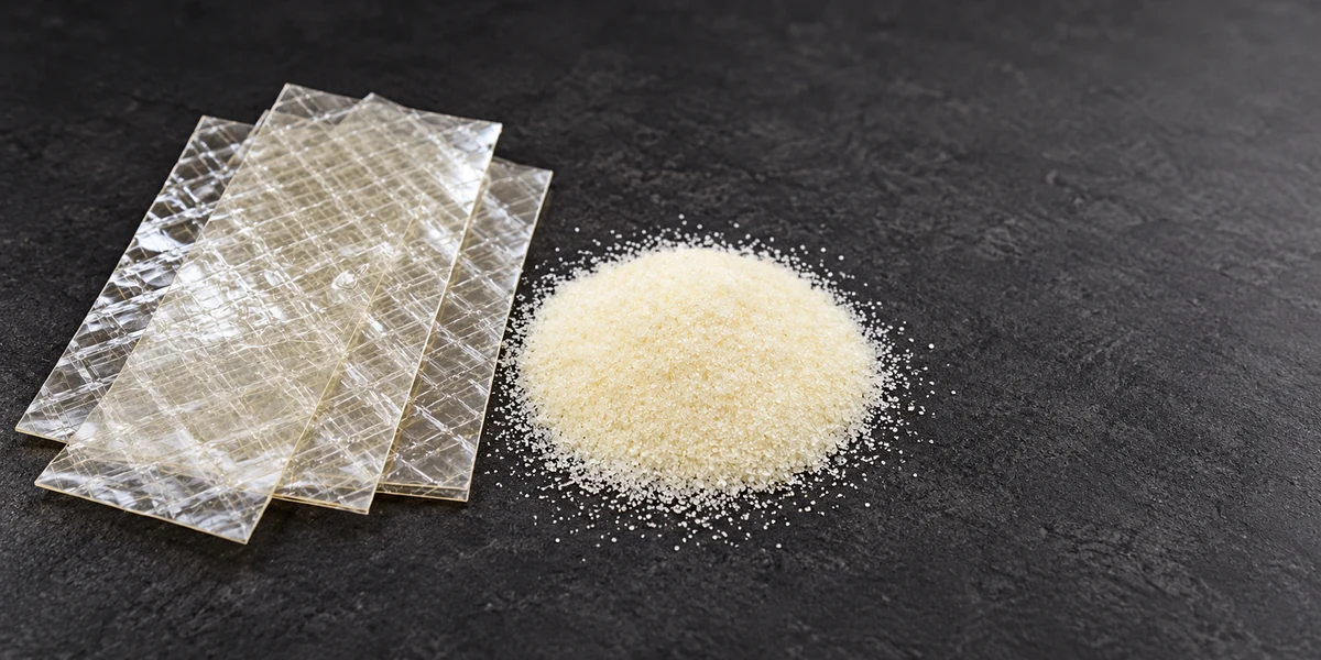 Dry gelatin sheets beside powdered gelatin on a work surface