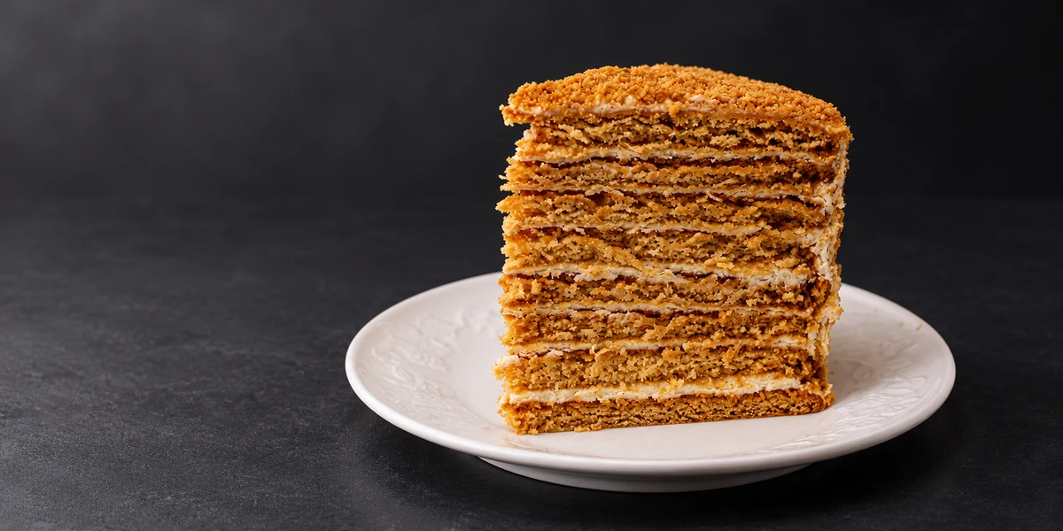 A slice of honey layer cake showing many thin layers and cream
